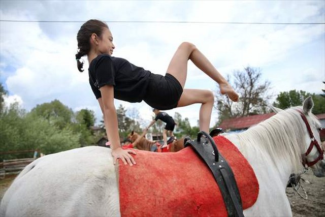 Küçük çocuklardan at üzerinde cimnastik gösterisi