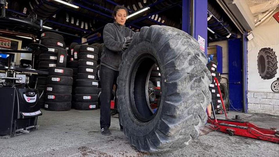 Sahada top koşturan genç kız, oto lastik dükkanında da babasına yardımcı oluyor