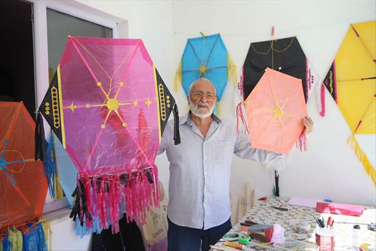 Evinin balkonunda yaptığı uçurtmalarla çocukları sevindiriyor